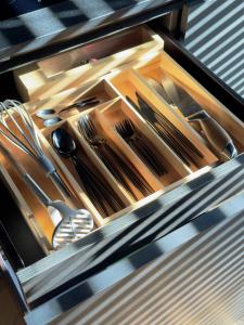 a drawer with knives and utensils in it at CrownPlaza Boutique & Central in Chişinău +12 photos