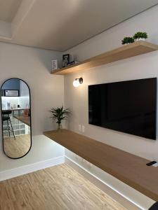 a living room with a large flat screen tv on a wall at Flat Ibirapuera Unifesp Metrô in Sao Paulo