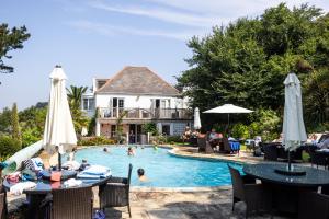 a swimming pool with people in a house at The White House Hotel in Herm