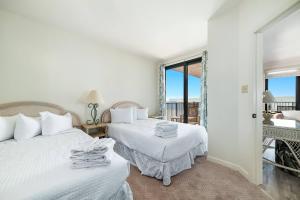 2 bedden in een witte kamer met een balkon bij Four Seasons 904W in Orange Beach