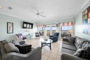 a living room with couches and chairs and a table at Sea-Side in Dauphin Island