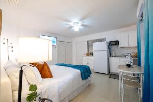 a bedroom with a bed and a table and a kitchen at 2 PPL 5 mins to Golf Courses Patio Pets BBQ in Wellington