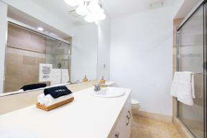 a white bathroom with a sink and a mirror at 2 PPL 5 mins to Golf Courses Patio Pets BBQ in Wellington