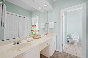 a white bathroom with a sink and a toilet at Sea-Side in Dauphin Island +23 photos