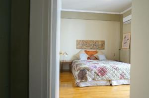 a bedroom with a bed with a floral bedspread at The Belgian Connection in Koukaki in Athens