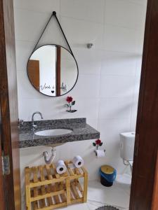 a bathroom with a sink and a mirror at Casa dos Sonhos - Pé na areia, Churrasqueira, Monitoramento 24 horas in Itanhaém +63 photos