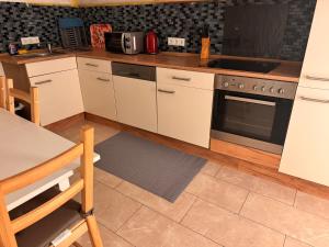 a kitchen with white cabinets and a stove top oven at A&V Apartments Arena Schalke in Gelsenkirchen