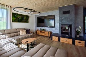 a living room with a couch and a flat screen tv at Vila Albatros TeePoint 15 in Heřmanice