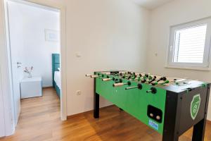 einem grünen und schwarzen Tischfußball in einem Zimmer in der Unterkunft Villa Trapezium - private heated pool & table soccer in Kaštela