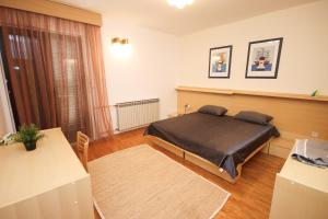 ein Schlafzimmer mit einem Bett und einem Tisch darin in der Unterkunft Apartment Macan in Cavtat