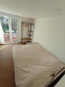 a bed in a white room with a window at studio L'opale in Assesse
