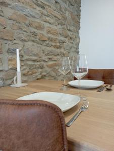 a wooden table with two wine glasses and a candle at studio L'opale in Assesse +6 photos