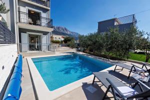 ein Schwimmbad vor einem Gebäude in der Unterkunft Villa Trapezium - private heated pool & table soccer in Kaštela