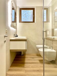a bathroom with a sink and a tub and a toilet at Casa Cinzia in Gravedona