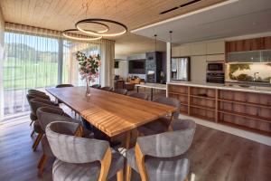 a kitchen and dining room with a wooden table and chairs at Vila Albatros TeePoint 15 in Heřmanice