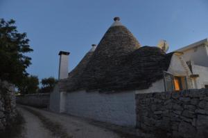 an old stone building with a thatched roof at Dimore Barsento in Alberobello