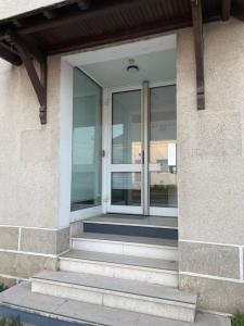 une porte vitrée sur le côté d'un bâtiment dans l'établissement Les Chambres de la Gare, à Noyers-sur-Cher