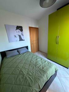 a bedroom with a green bed and a green cabinet at Top Floor Apartments in Pefkochori