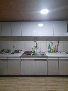 Una cocina con gabinetes blancos y un fregadero. en 3M sobe, en Bečej