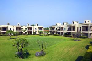 a view of a building with a green yard at Lemon Tree Hotel, Tarudhan Valley, Manesar in Gurgaon