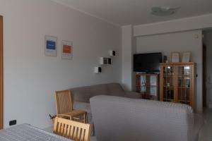 a living room with a couch and a tv at DeGasperi Home in Manfredonia