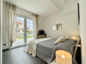 Il Relax con Vista Mare - Free Parking, Wi-Fi في لوانو: غرفة نوم بها سرير ونافذة كبيرة +21 صورة