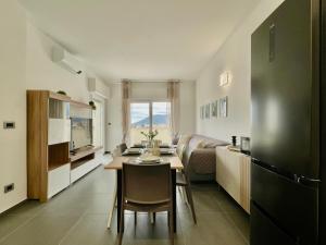 Il Relax con Vista Mare - Free Parking, Wi-Fi في لوانو: مطبخ وغرفة معيشة مع طاولة وكراسي
