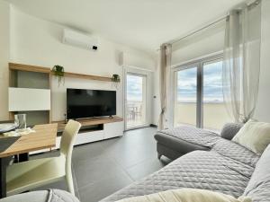 Il Relax con Vista Mare - Free Parking, Wi-Fi في لوانو: غرفة معيشة بها سرير ومكتب وتلفزيون