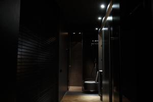 a bathroom with a toilet in a dark room at CrownPlaza Boutique & Central in Chişinău