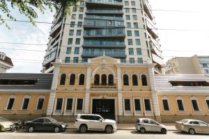 a building with cars parked in front of a tall building at CrownPlaza Boutique & Central in Chişinău