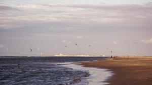 a group of people flying kites on the beach at Hotel Atlantic Juist in Juist