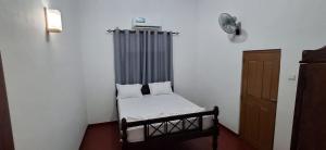 a small room with a bed and a fan at THE ANCHORAGE BEACH VILLA - Negombo in Negombo