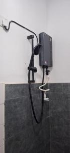 a bathroom with a black shower hose and a tv at THE ANCHORAGE BEACH VILLA - Negombo in Negombo