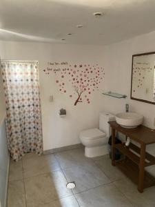un bagno con servizi igienici e un albero con cuori appesi al muro di Posada Casa Topiltzin a Tepoztlán