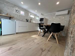 Una cocina con mesa y sillas y un refrigerador. en Casinha do Souto, en Caminha