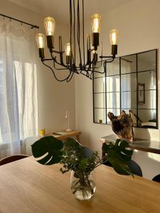a dining room with a vase on a table with a chandelier at Plaza Teobaldos in Pamplona +35 photos