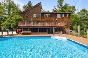 a house with a swimming pool in front of a house at Upper Saddle River Resort w Pool, Hot Tub & Lake in Airmont