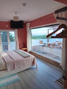 a bedroom with a bed and a large window at Alojamento local Patudos, Suite com terraço privado in Tavira