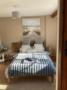 a bedroom with a bed and a painting on the wall at Guest Suite at 31 Little England in Milborne Saint Andrew