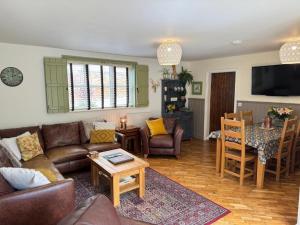 a living room with a couch and a table at Vale View Cottages - The Stables in Prestatyn +27 photos