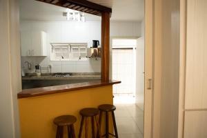 a kitchen with a counter and stools in a room at Bouganville Suites in Angra dos Reis