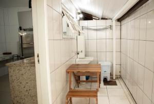 a bathroom with a toilet and a table in it at Bouganville Suites in Angra dos Reis