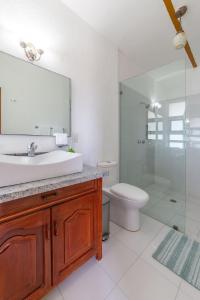 Un baño con lavabo, inodoro y espejo. en Quinta Nayarit con alberca privada, en Bucerías