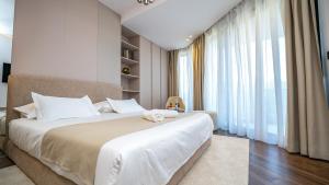 特罗吉尔Luxury Villa Trogir Hills的卧室里有一张大床，床上放着一只毛绒玩具 更多110张照片