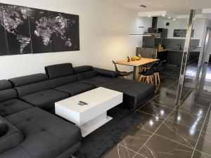 a living room with a black couch and a table at CasaNova in Cologne