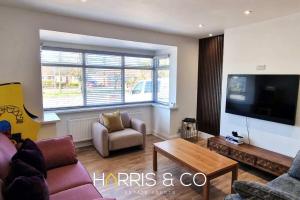 a living room with a couch and a tv at The Poulton Paradise in Poulton le Fylde