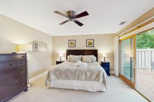 ein Schlafzimmer mit einem Bett und einem Deckenventilator in der Unterkunft Tupelo Cottage in Hilton Head Island