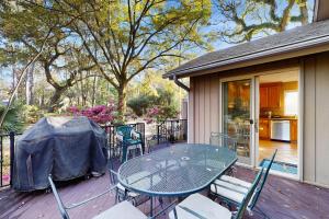 eine Terrasse mit Tisch und Stühlen auf einem Deck in der Unterkunft Tupelo Cottage in Hilton Head Island