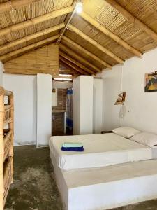 a bedroom with a large bed and wooden ceilings at kontiki in Máncora