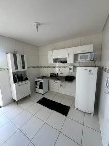 a kitchen with white appliances and white tile floors at Apartamento em Petrolina in Petrolina